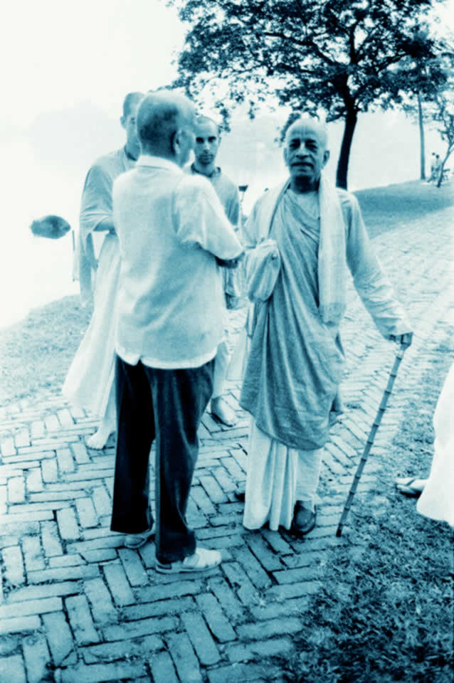 Prabhupada with cane in hand talking to an older gentleman.