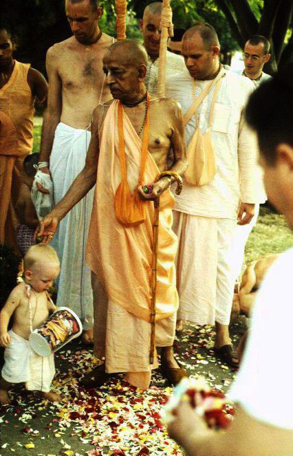 Prabhupada blesses a small boy with drum.